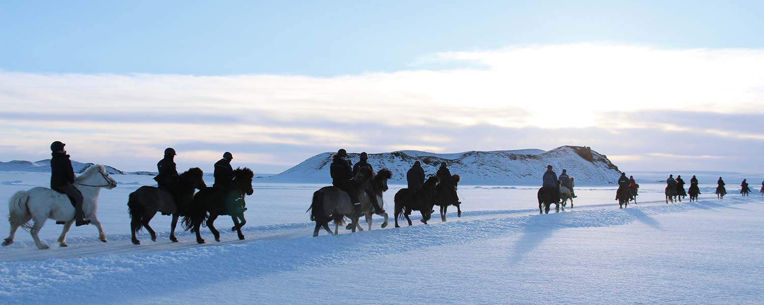 Rider islandshäst på frusna sjöar på Island